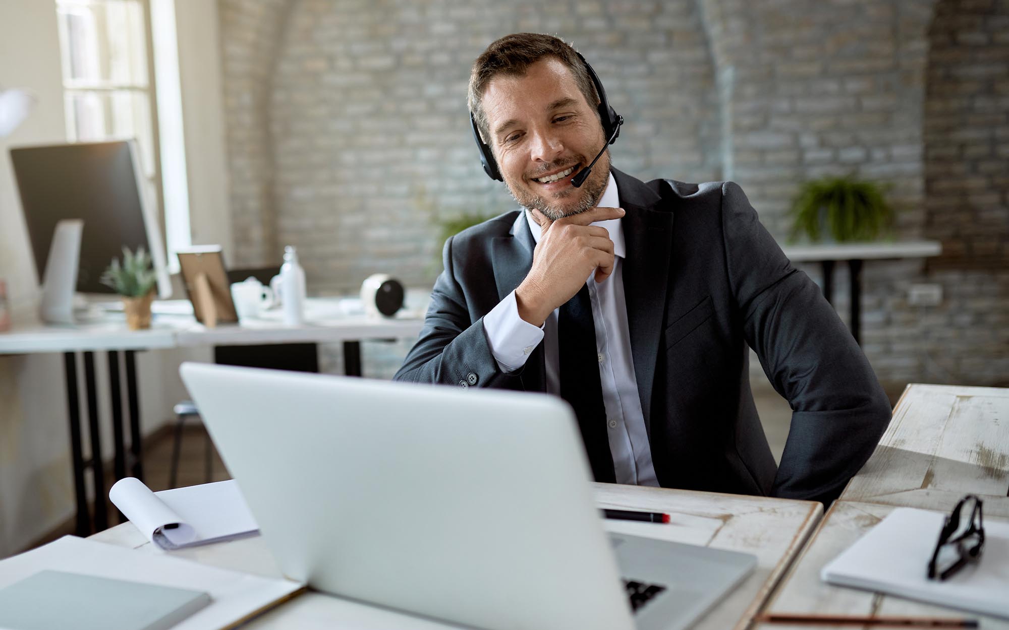 Image of a business person using a computer and a headset. Image of a business person using a computer and a headset.