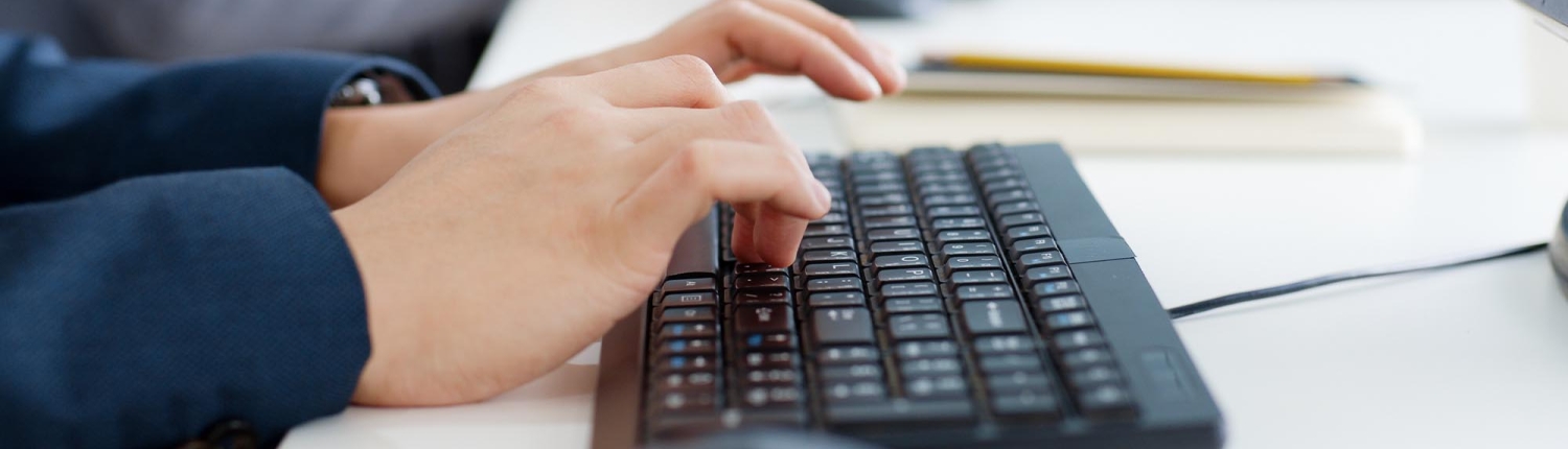 Side view of a man's hands typing on a keyboard