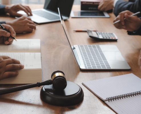 Image of lawyers sitting at a table with laptops.