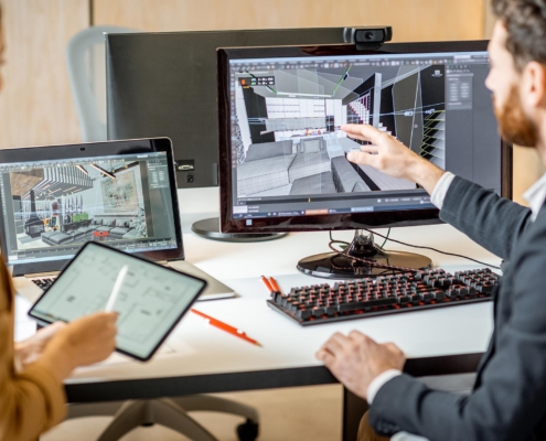 Two people reviewing architectural models on a computer.