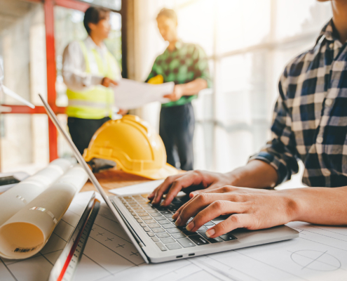 Engineers work as a team with blueprints for architectural plans