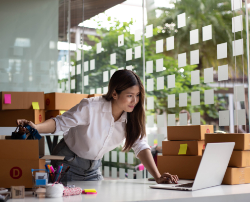 Person running small business looking at laptop in office